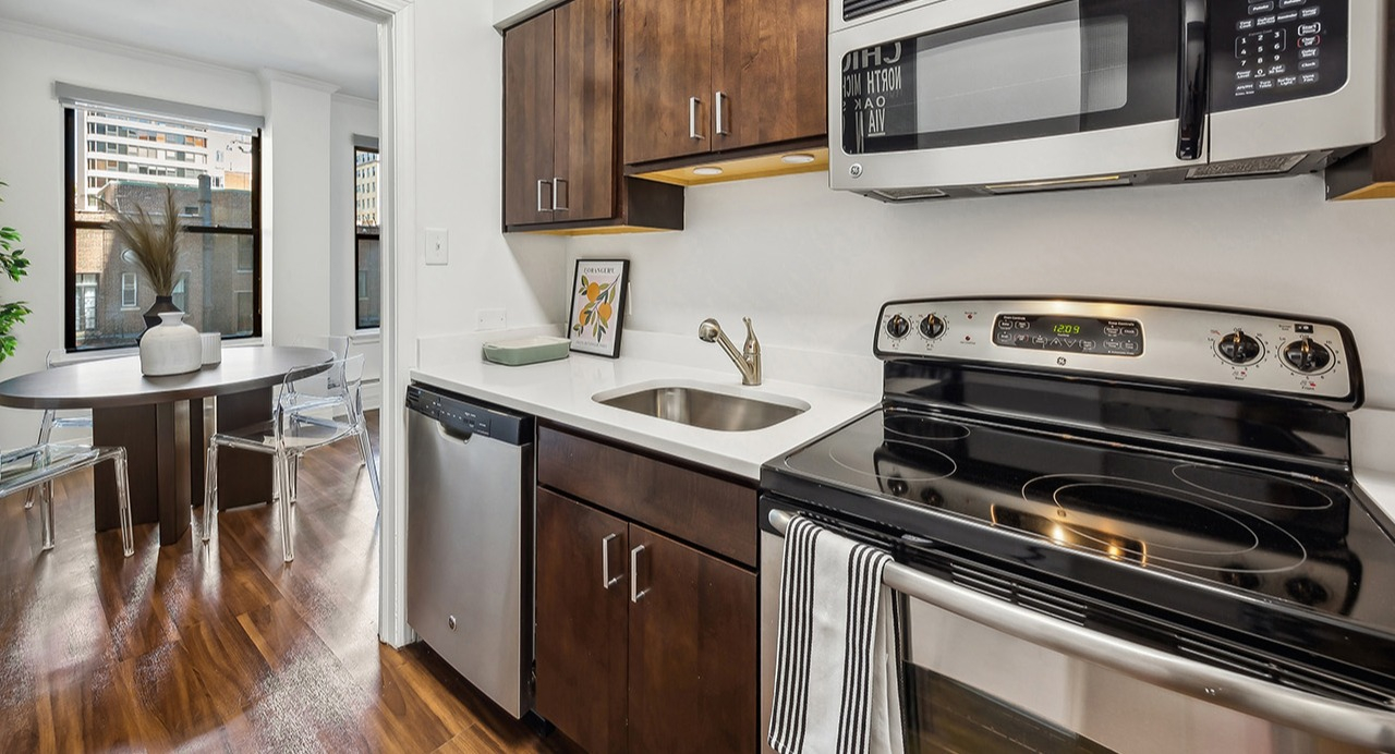 Efficient apartment kitchen at The Seneca Apartments in Chicago, featuring stainless steel appliances and an adjacent dining area