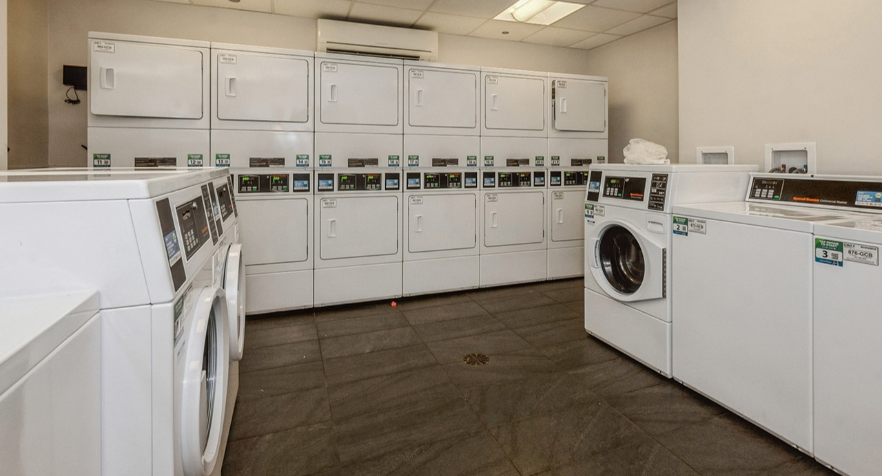 Spacious communal laundry room at The Seneca Apartments in Chicago, featuring multiple washers and dryers for resident convenience