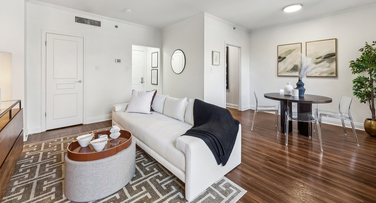 Bright open-concept living and dining room at The Seneca Apartments in Chicago, featuring a white sofa, modern decor, and hardwood floors