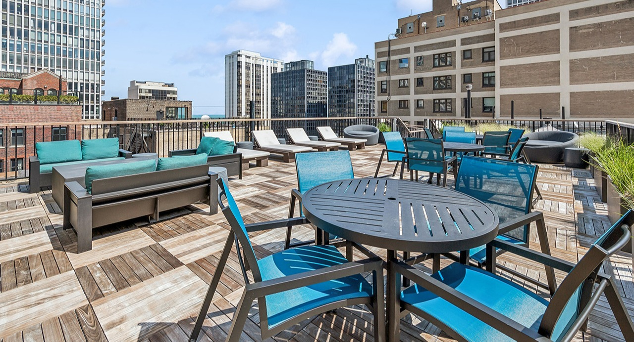 Expansive rooftop deck at The Seneca Apartments in Chicago, featuring outdoor seating, dining tables, and city views