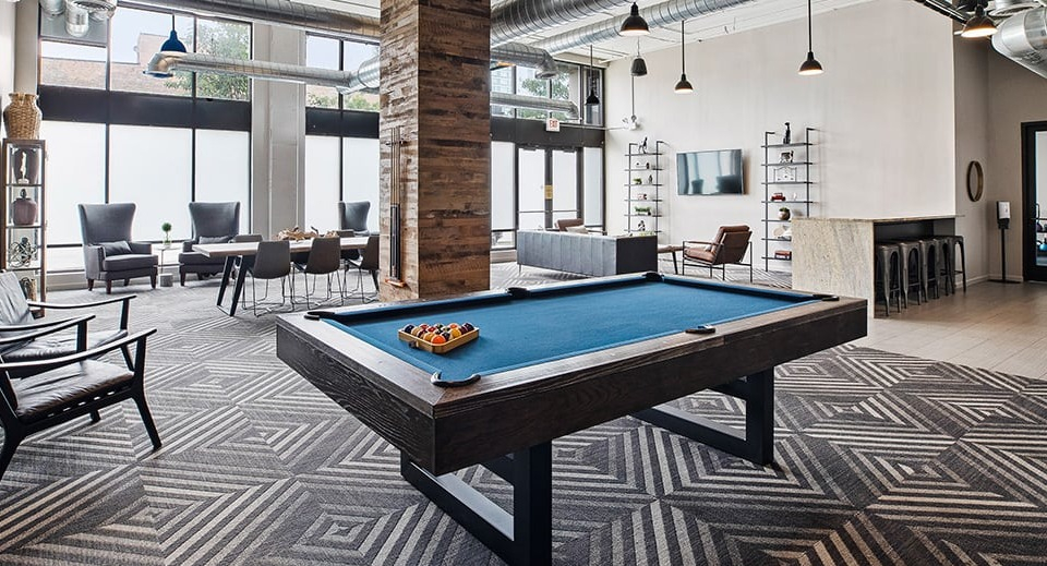 Large amenity lounge at The Shelby in Chicago, featuring a pool table, multiple seating areas, and a communal kitchen