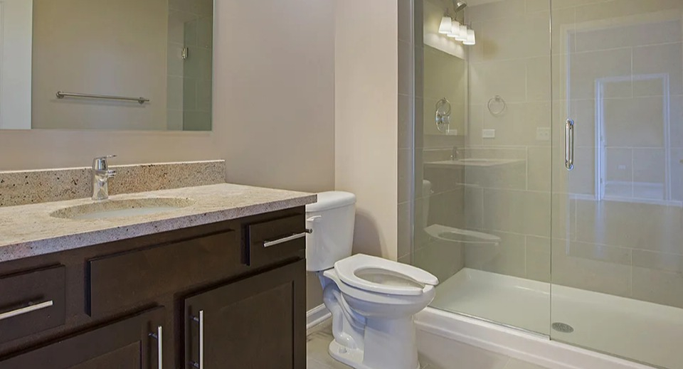 Modern bathroom at The Shelby in Chicago, featuring a spacious walk-in shower with glass enclosure and a stylish vanity