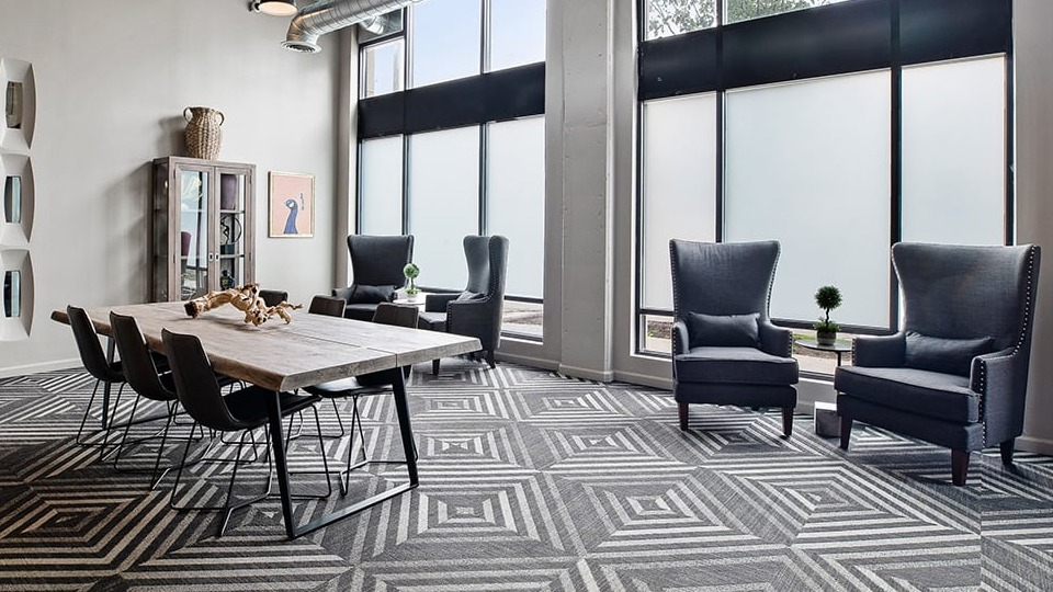 Versatile co-working and dining area at The Shelby in Chicago, featuring a large communal table, comfortable chairs, and high ceilings