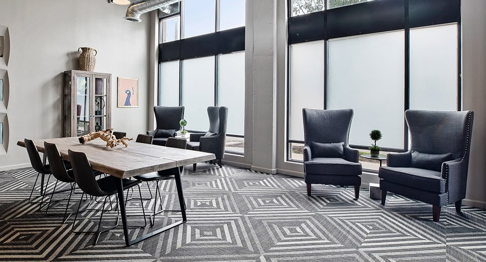 Versatile co-working and dining area at The Shelby in Chicago, featuring a large communal table, comfortable chairs, and high ceilings