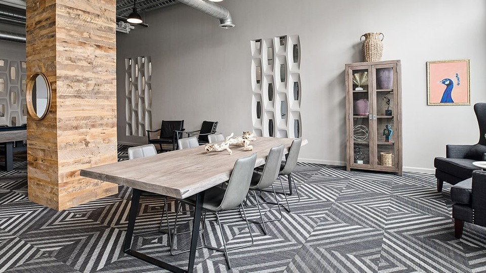 Multifunctional dining and game room at The Shelby in Chicago, featuring a long communal table, a pool table, and lounge seating