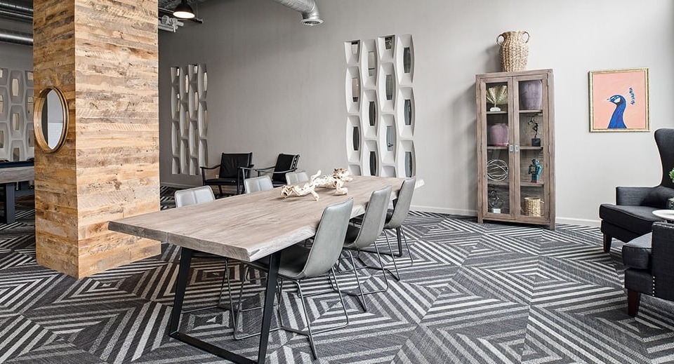 Multifunctional dining and game room at The Shelby in Chicago, featuring a long communal table, a pool table, and lounge seating