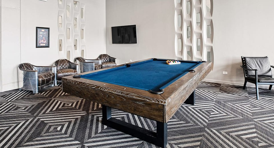 Exciting game room at The Shelby in Chicago, featuring a pool table, comfortable seating, and industrial-chic design elements