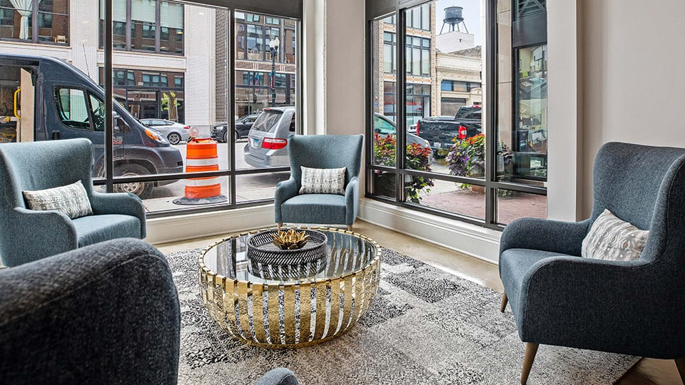 Inviting lounge area at The Shelby in Chicago, featuring comfortable armchairs, a stylish coffee table, and large windows