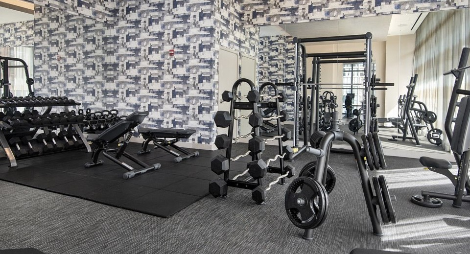 A comprehensive gym and fitness center equipped with various weight machines, free weights, and modern design at The Sinclair in Chicago
