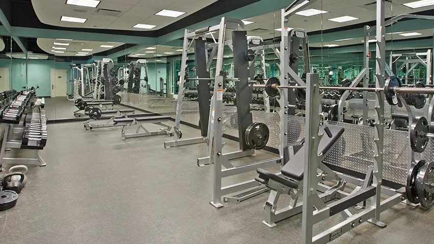 A comprehensive fitness center with a wide range of free weights, benches, and strength training machines at The Streeter in Chicago
