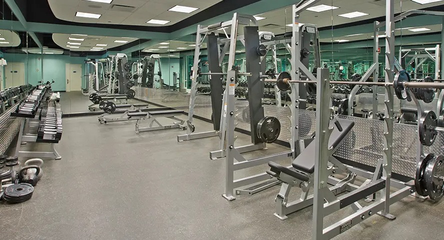 A comprehensive fitness center with a wide range of free weights, benches, and strength training machines at The Streeter in Chicago