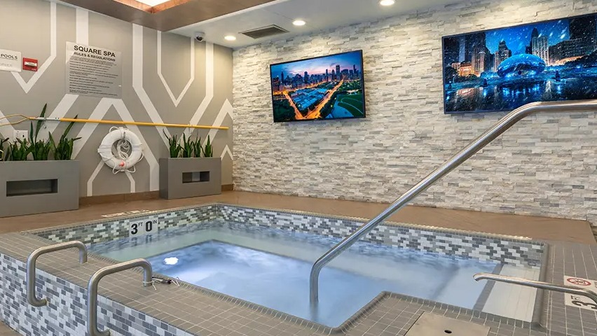 A luxurious indoor spa area with a large hot tub, comfortable seating, and modern decor, perfect for relaxation at The Streeter in Chicago
