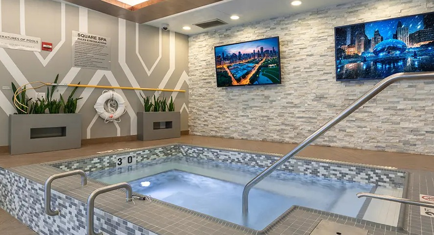 A luxurious indoor spa area with a large hot tub, comfortable seating, and modern decor, perfect for relaxation at The Streeter in Chicago