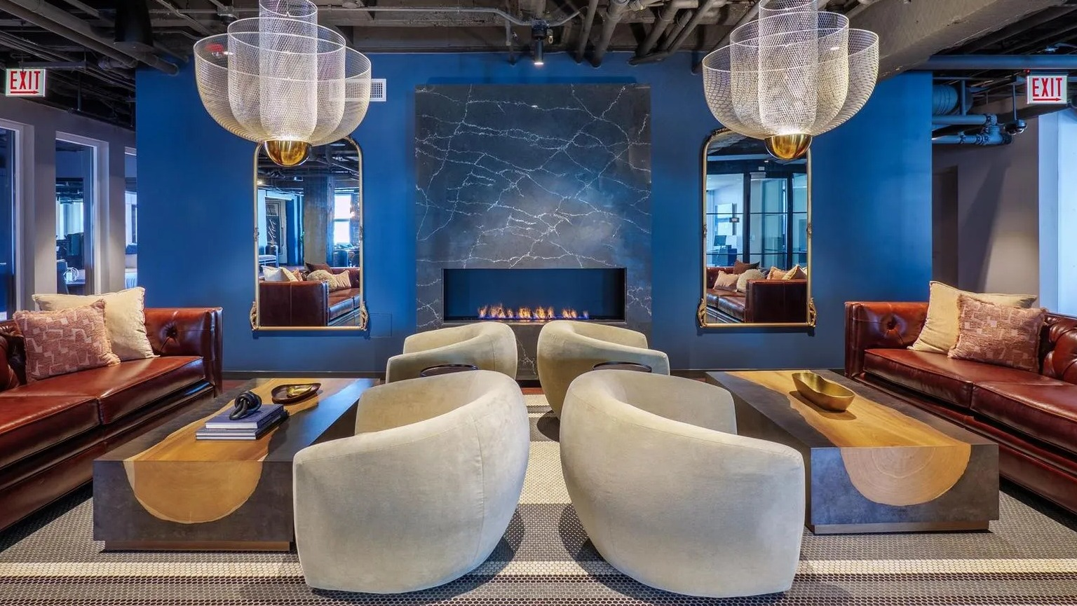 A grand resident lounge featuring comfortable sofas, stylish chairs, and a striking modern fireplace, perfect for relaxation at The Thompson at Fulton Market in Chicago
