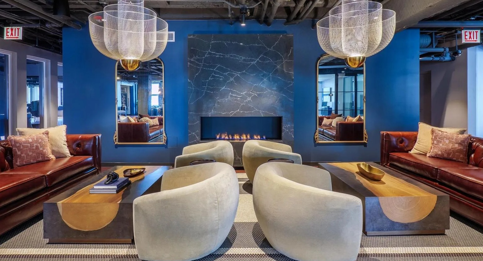 A grand resident lounge featuring comfortable sofas, stylish chairs, and a striking modern fireplace, perfect for relaxation at The Thompson at Fulton Market in Chicago