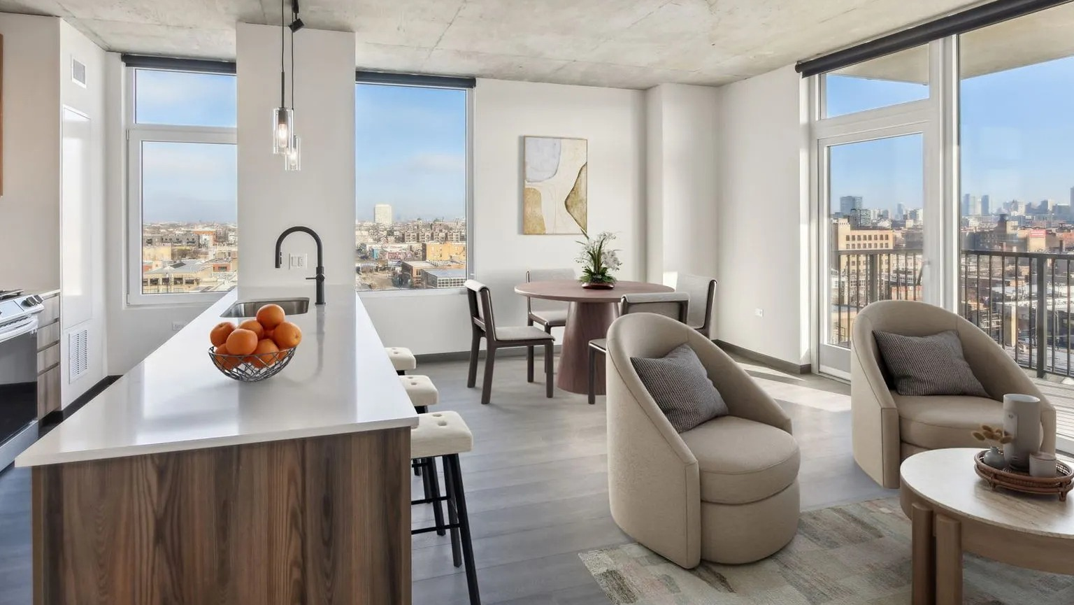 A bright open-concept apartment with a modern kitchen island, dining area, and a spacious living room with city views at The Thompson at Fulton Market in Chicago