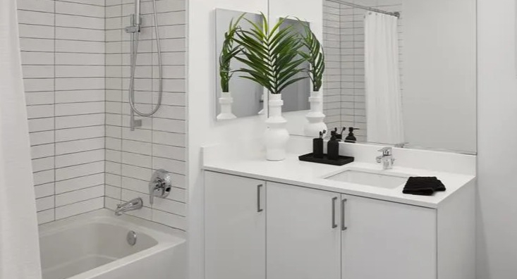Modern bathroom at The Van Buren apartments in Chicago with a white subway tiled shower and sleek vanity
