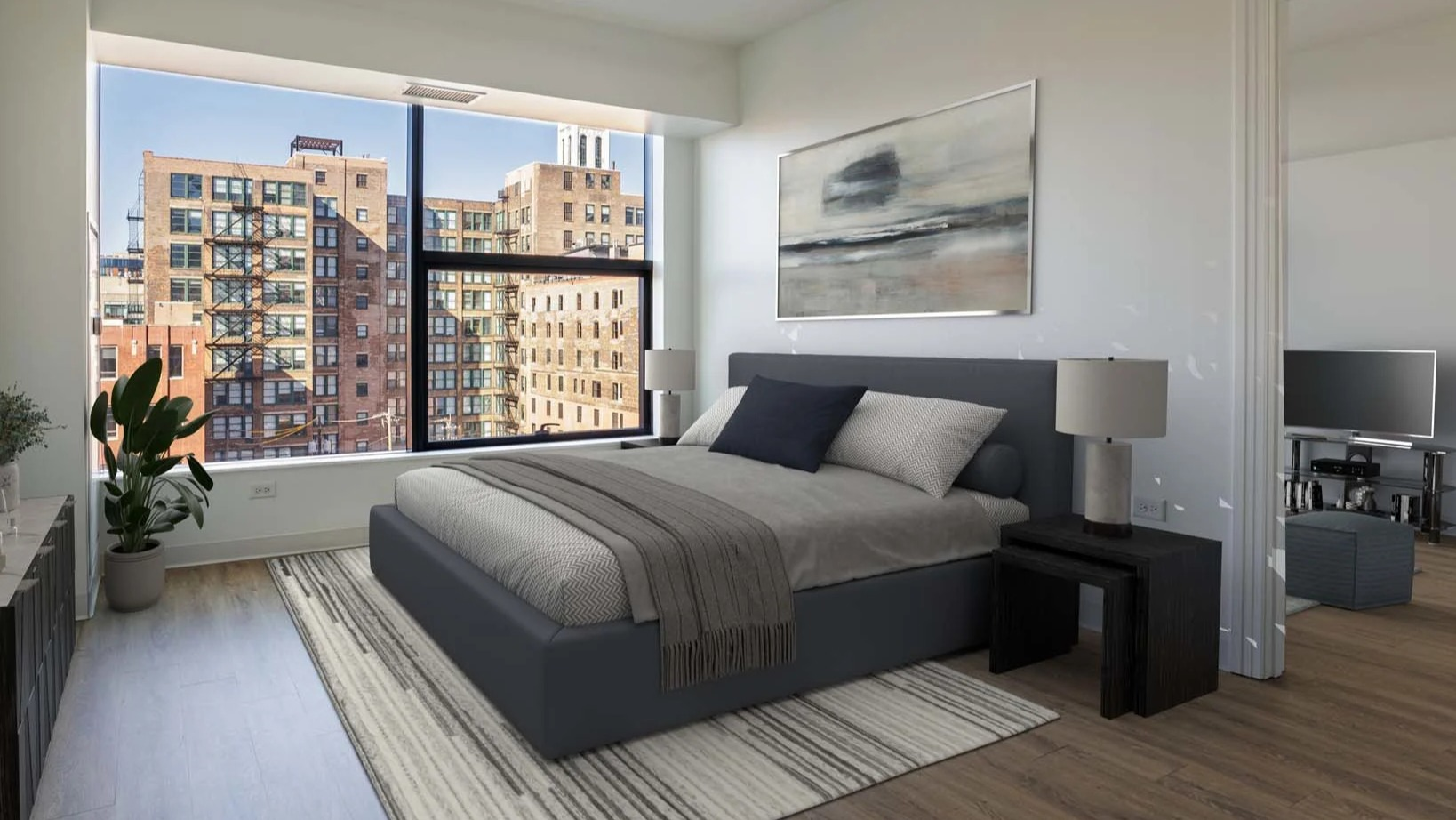 Cozy bedroom with a large window offering expansive city views at The Van Buren apartments in Chicago