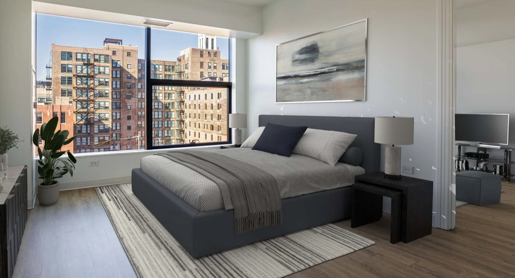 Cozy bedroom with a large window offering expansive city views at The Van Buren apartments in Chicago