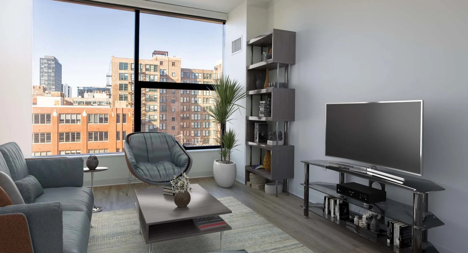 Modern living room at The Van Buren apartments with a comfortable sofa, stylish furniture, and large windows overlooking Chicago
