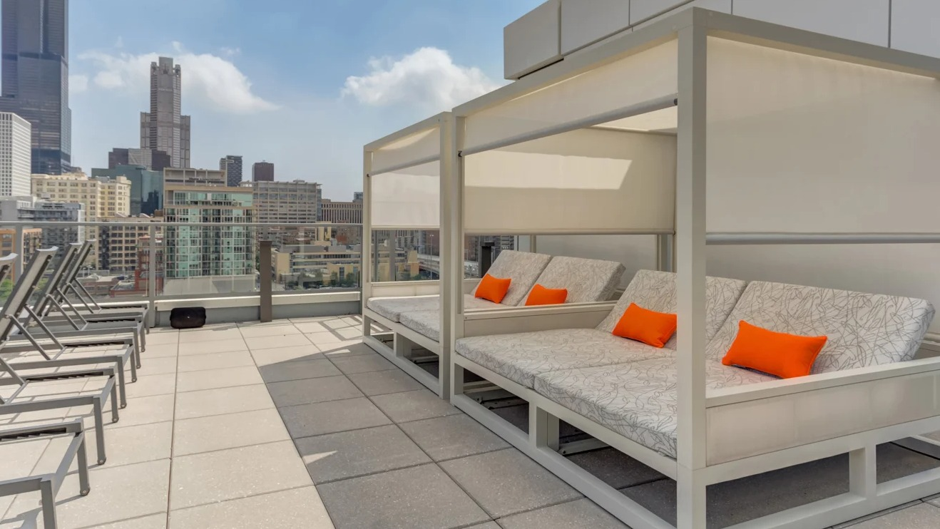 Expansive rooftop deck at The Van Buren in Chicago, offering lounge chairs and incredible views of the city skyline