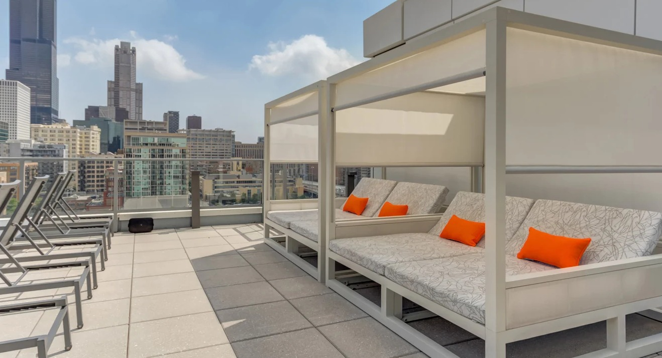 Expansive rooftop deck at The Van Buren in Chicago, offering lounge chairs and incredible views of the city skyline