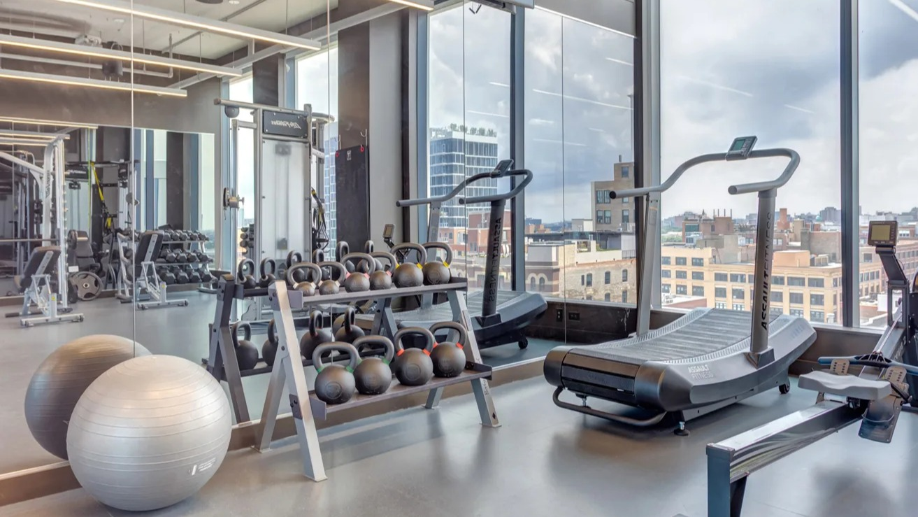 State-of-the-art gym at The Van Buren in Chicago, equipped with cardio machines, weights, and large windows