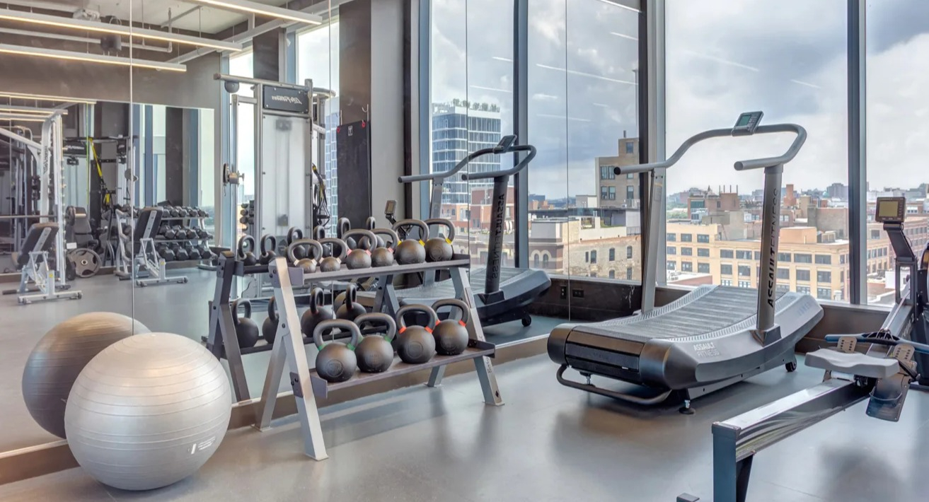 State-of-the-art gym at The Van Buren in Chicago, equipped with cardio machines, weights, and large windows