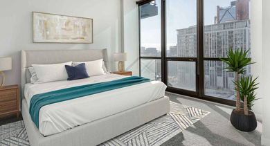 Bright bedroom with a large bed, modern decor, and expansive windows offering stunning city views at Trio Apartments in Chicago