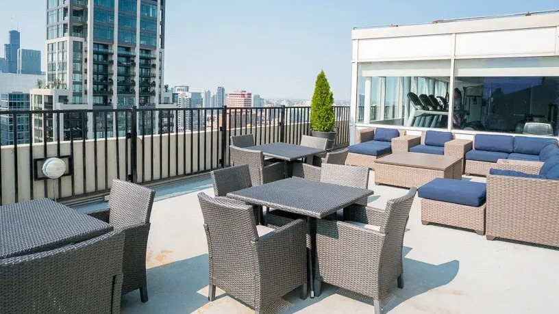 Spacious rooftop patio with various seating areas, outdoor dining tables, and expansive city views at Two East Oak in Chicago