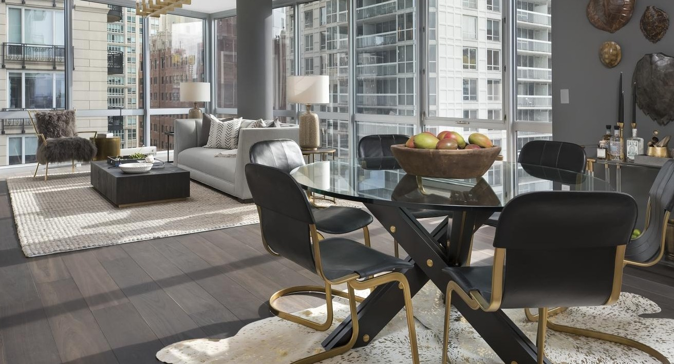 Modern open-plan dining and living room with floor-to-ceiling windows, dark wood floors, and stylish furnishings at Two West, Chicago