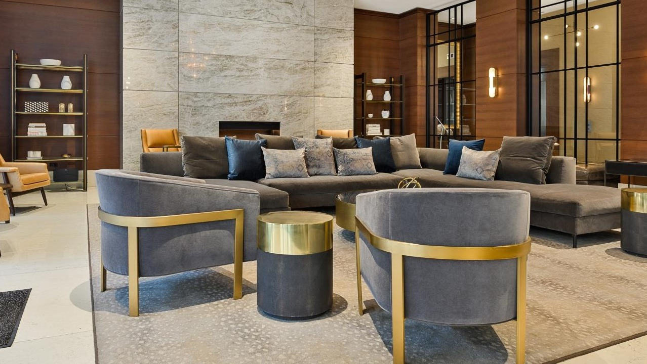 Elegant and spacious lobby lounge area with comfortable seating, a grand fireplace, and stylish decor at Two West, Chicago