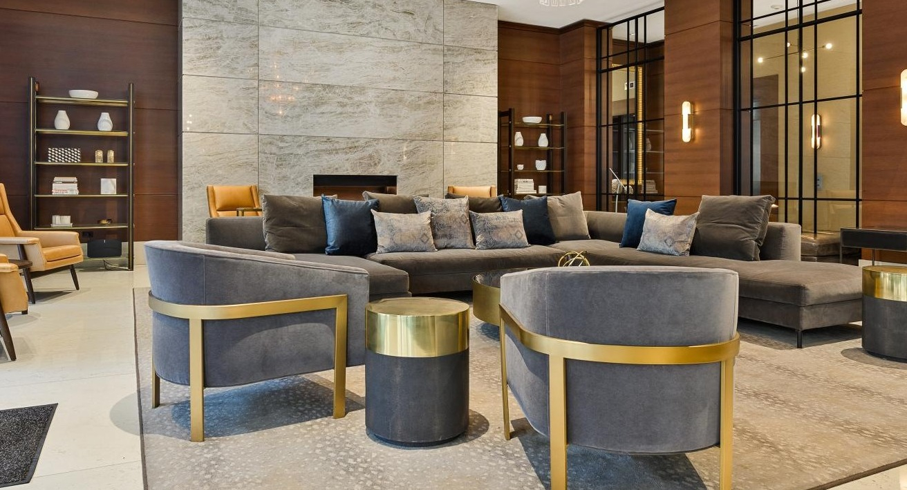 Elegant and spacious lobby lounge area with comfortable seating, a grand fireplace, and stylish decor at Two West, Chicago