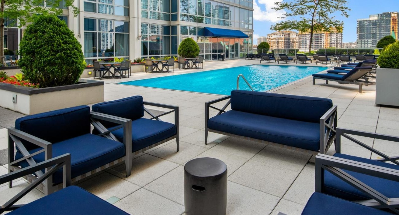 Outdoor pool deck with blue lounge chairs and seating areas, offering a luxurious amenity at Two West apartments in Chicago