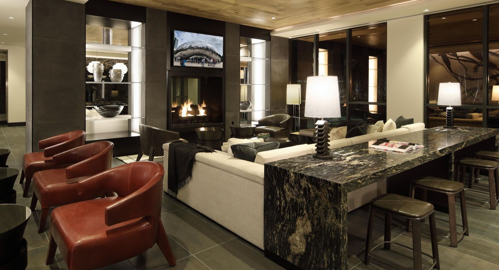 Elegant communal space with a cozy fireplace, high-top seating, and comfortable lounge furniture at Union West, Chicago