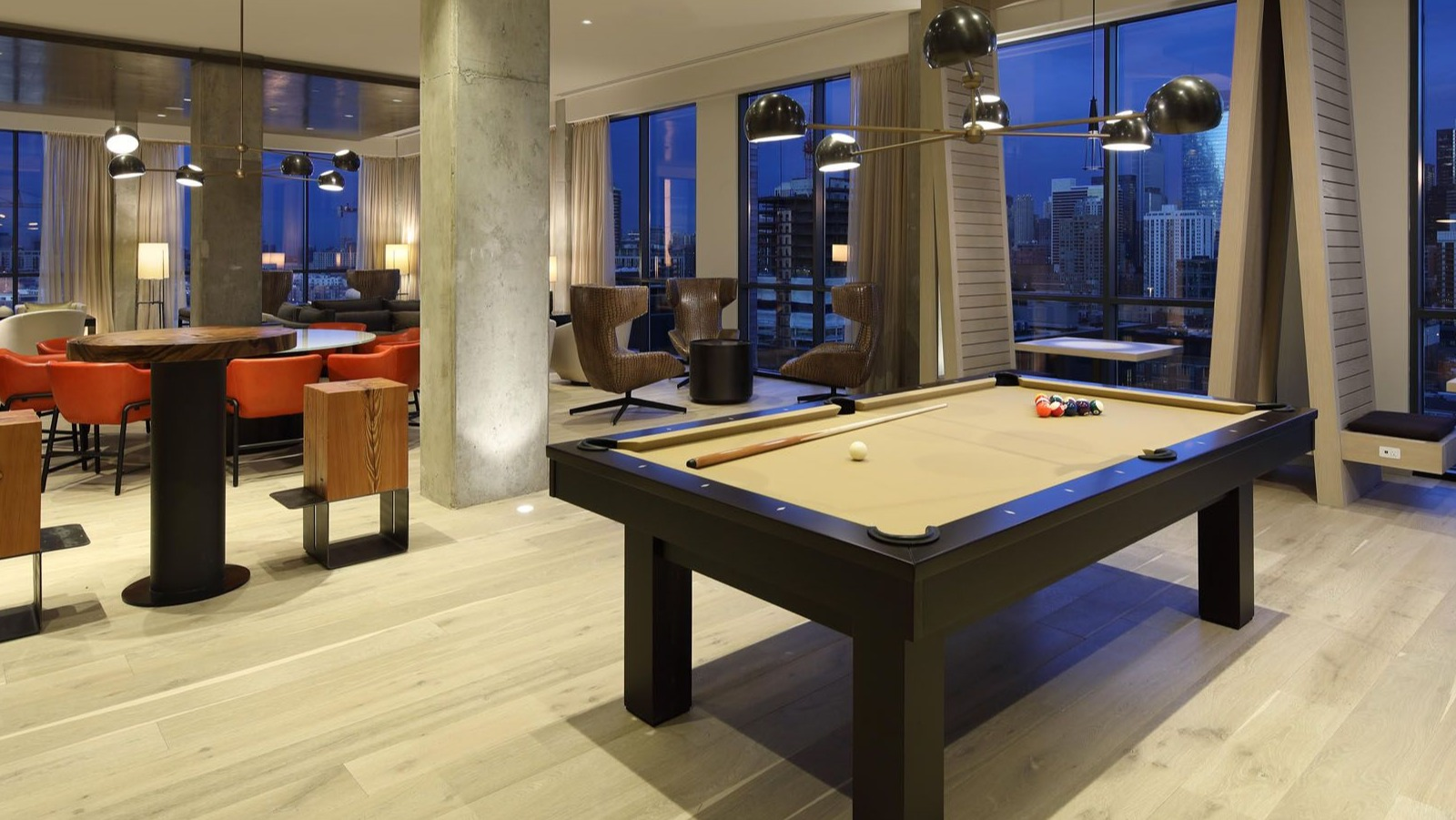 Lively game room featuring a billiards table, comfortable seating, and stunning city views at Union West apartments in Chicago