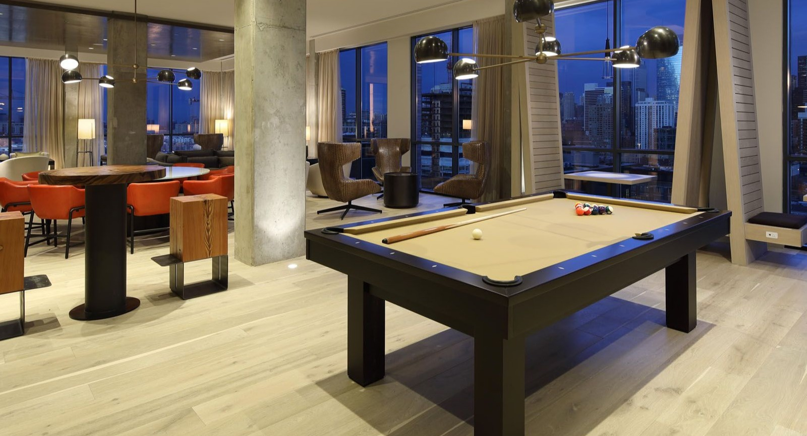 Lively game room featuring a billiards table, comfortable seating, and stunning city views at Union West apartments in Chicago