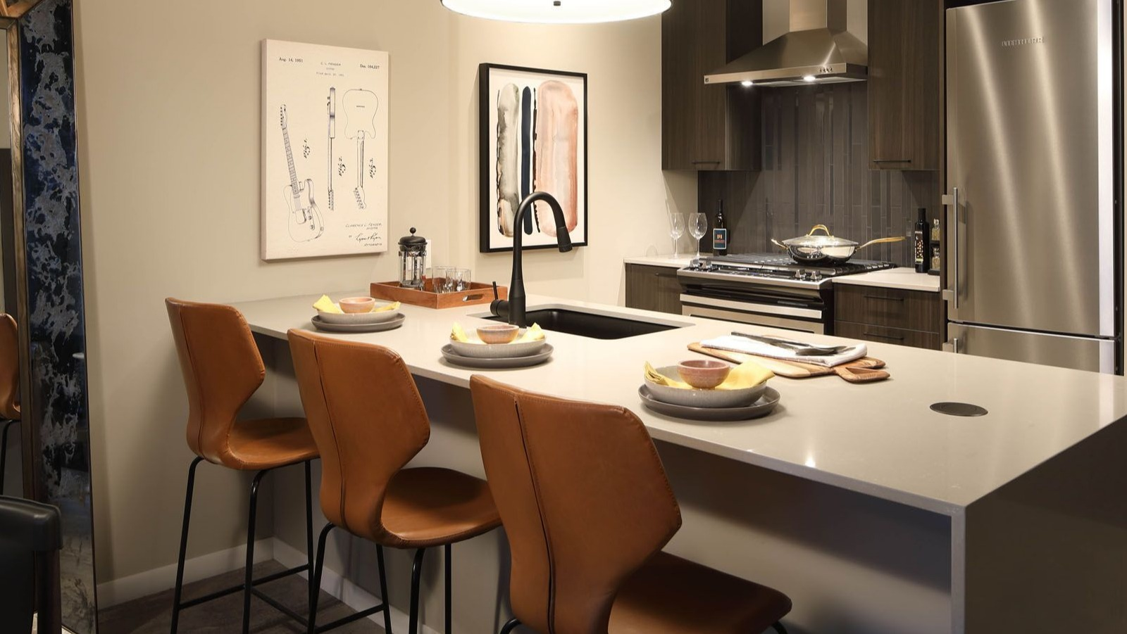 Stylish apartment kitchen with dark cabinetry, stainless steel appliances, and a large island with bar stools at Union West, Chicago