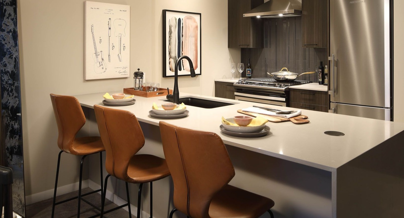 Stylish apartment kitchen with dark cabinetry, stainless steel appliances, and a large island with bar stools at Union West, Chicago