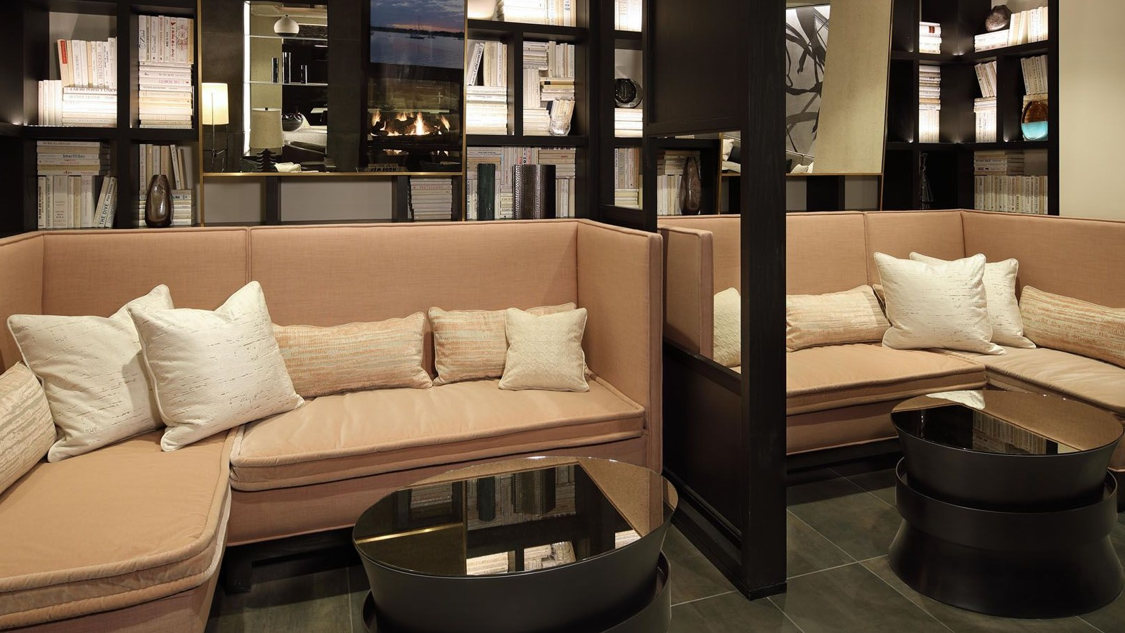 Cozy library lounge area with comfortable booth seating, built-in bookshelves, and soft lighting at Union West apartments in Chicago