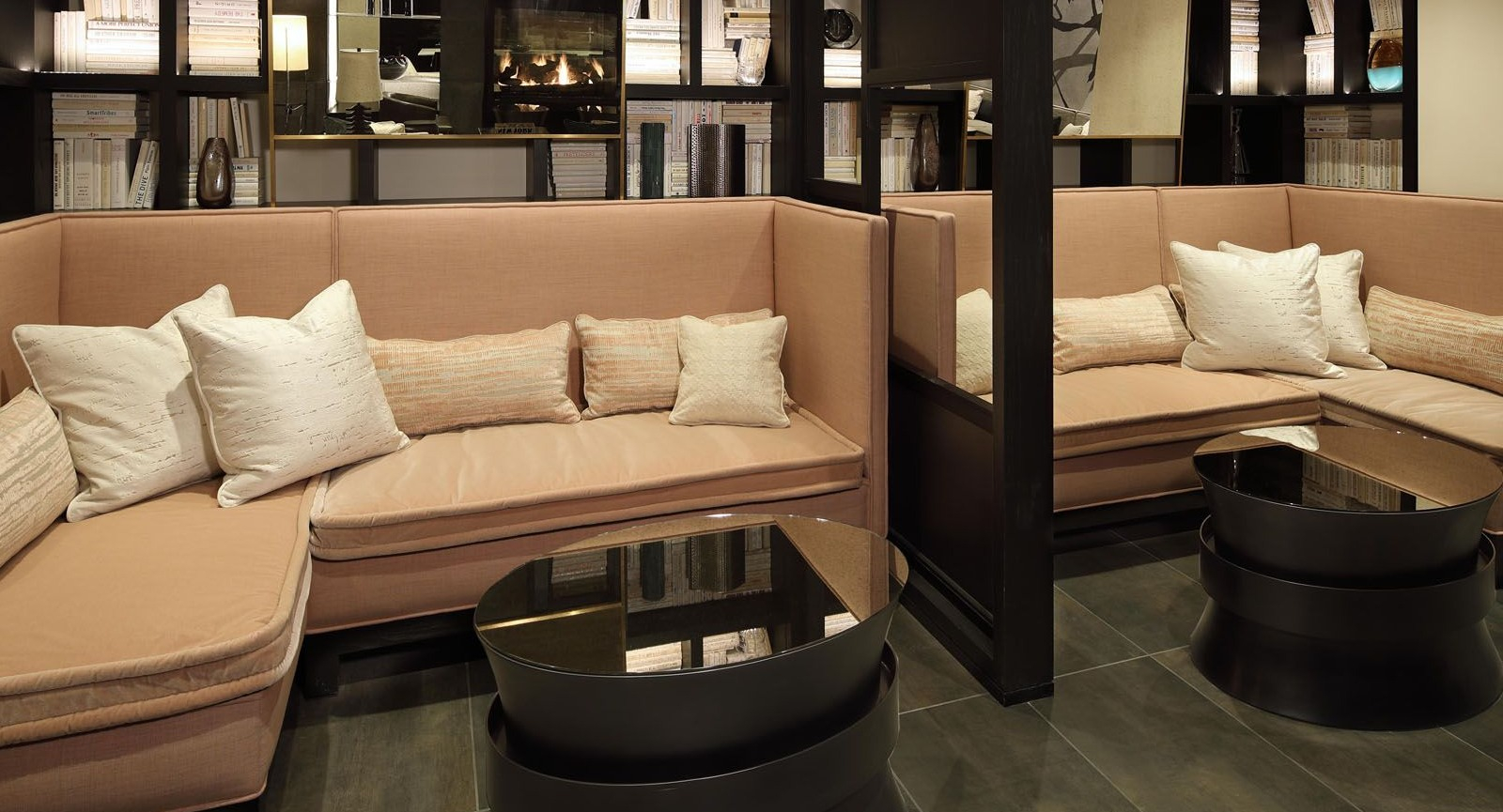 Cozy library lounge area with comfortable booth seating, built-in bookshelves, and soft lighting at Union West apartments in Chicago