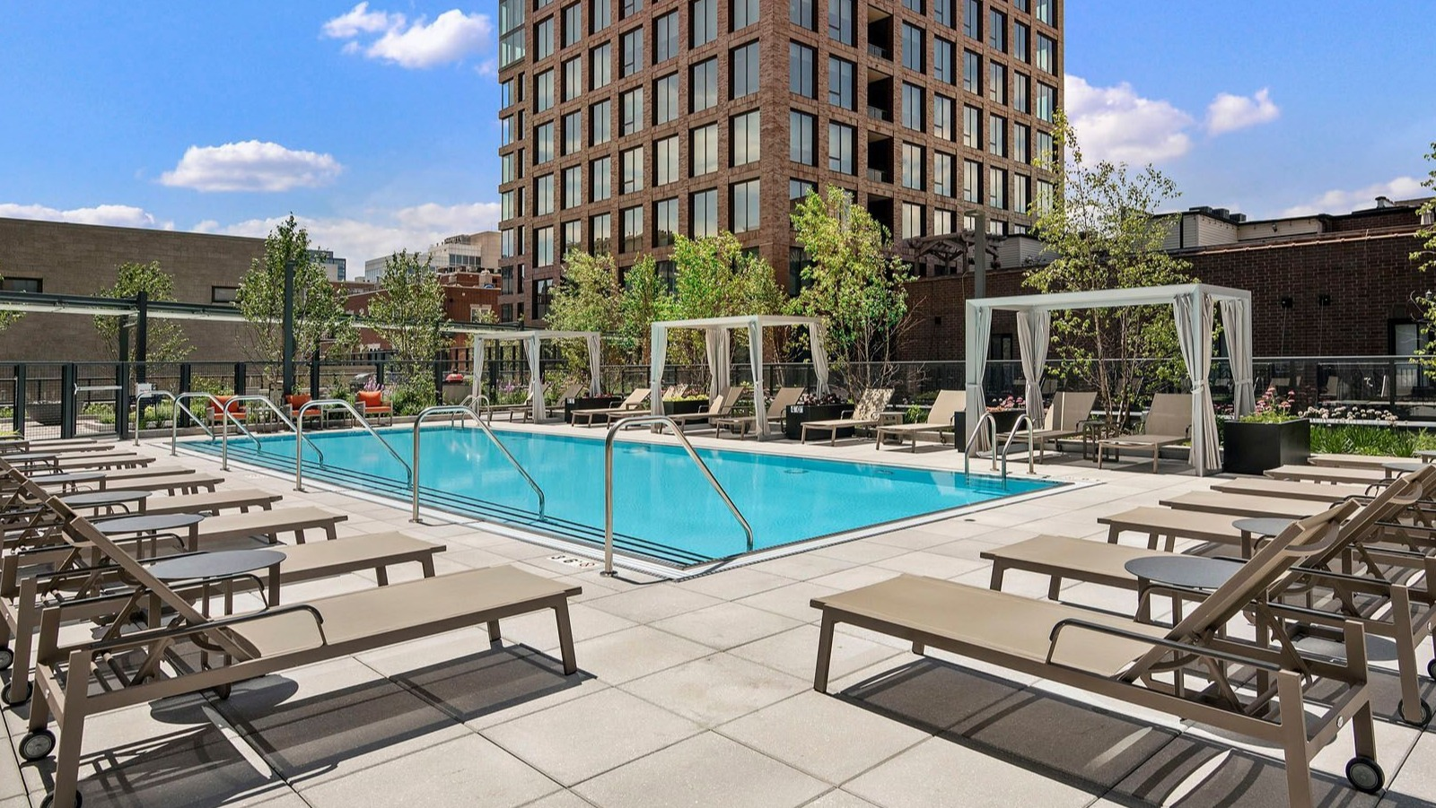 Stunning rooftop swimming pool with ample lounge seating and the impressive Chicago skyline as a backdrop at Union West