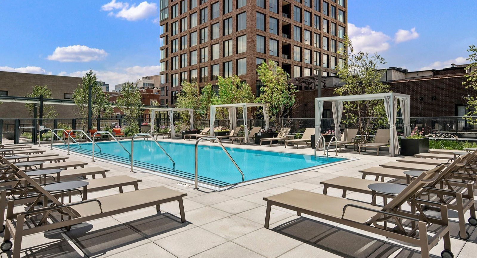 Stunning rooftop swimming pool with ample lounge seating and the impressive Chicago skyline as a backdrop at Union West