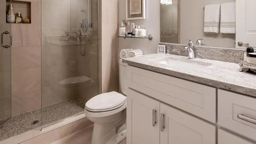 Modern bathroom with a spacious walk-in shower, granite vanity, and sleek fixtures, providing comfort at Wells Place, Chicago