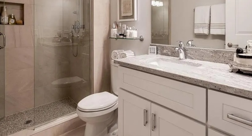 Modern bathroom with a spacious walk-in shower, granite vanity, and sleek fixtures, providing comfort at Wells Place, Chicago