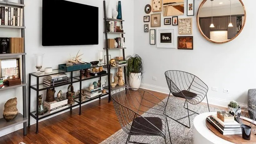 Chic living room with a gallery wall, ladder bookshelves, and modern furniture, showcasing unique style at Wells Place, Chicago