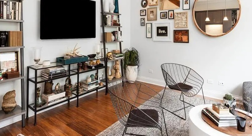 Chic living room with a gallery wall, ladder bookshelves, and modern furniture, showcasing unique style at Wells Place, Chicago