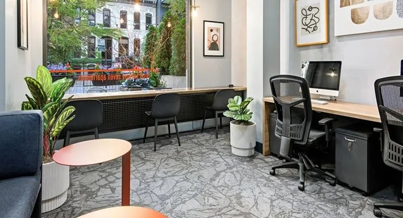 Modern coworking space with individual desks, comfortable seating, and abundant natural light at West77 Apartments in Chicago