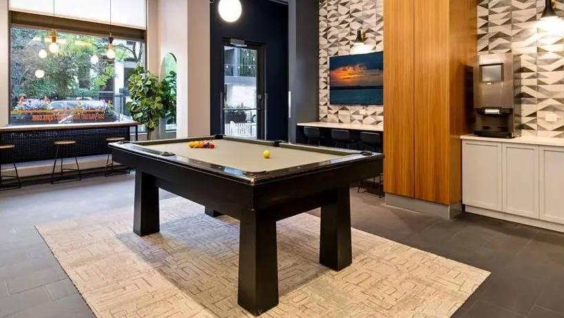 Chic game room featuring a billiards table, comfortable seating, and stylish patterned walls at West77 Apartments in Chicago