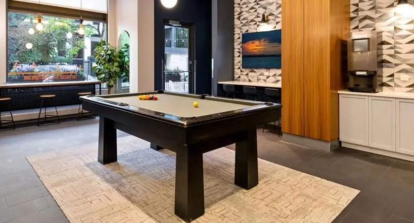 Chic game room featuring a billiards table, comfortable seating, and stylish patterned walls at West77 Apartments in Chicago